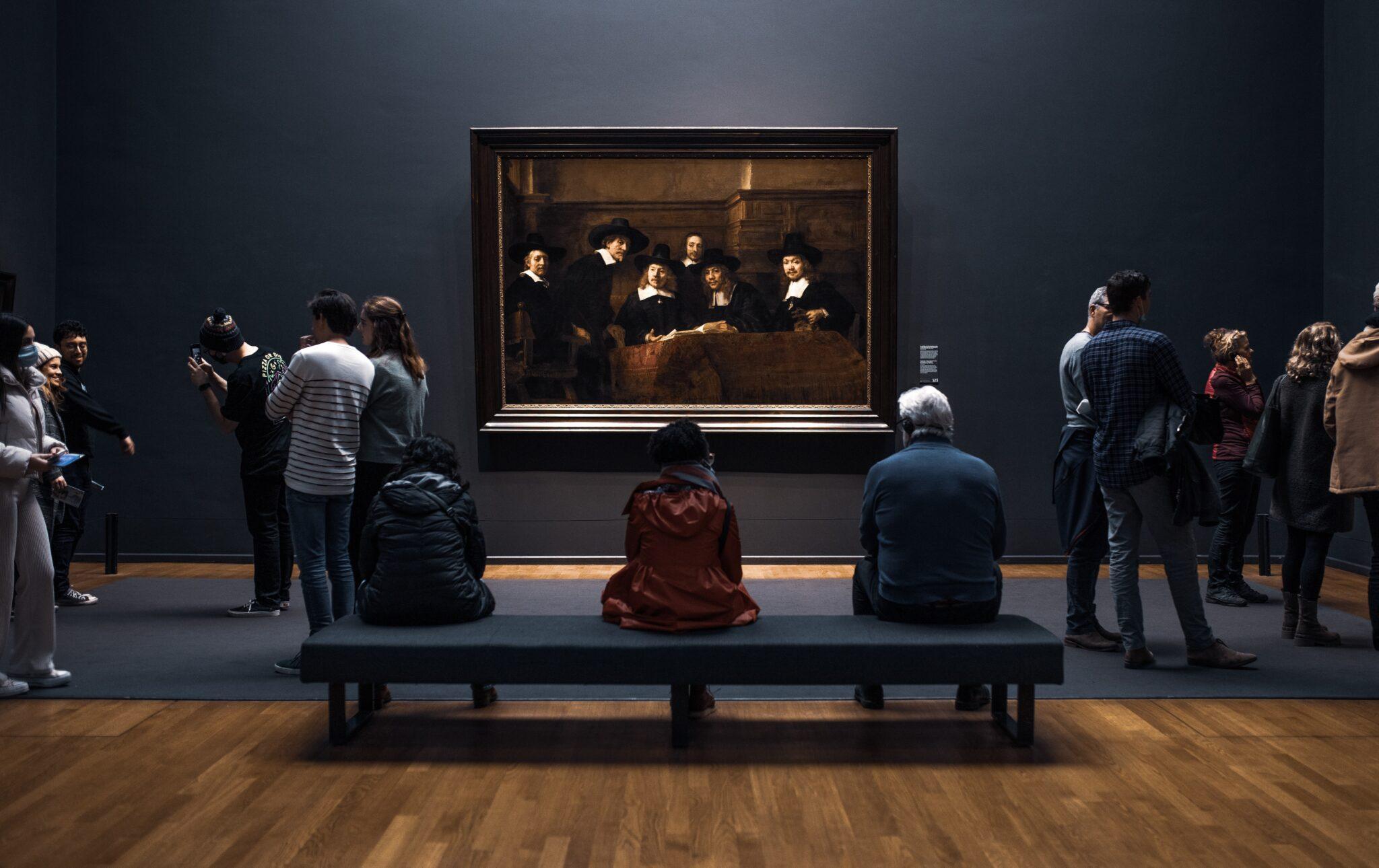 people looking at Rembrandt painting 'De Staalmeesters'' at Rijksmuseum