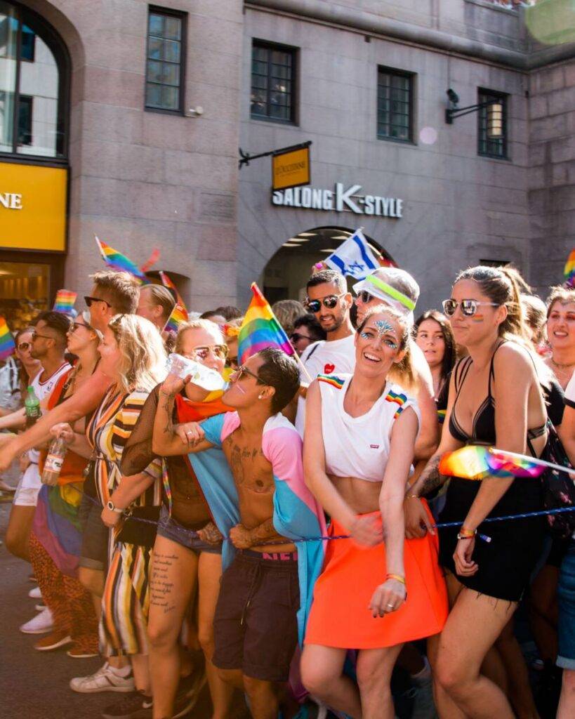Crowds celebrating WorldPride Amsterdam 2026 with Pride flags in Amsterdam city centre